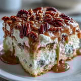 Buttery toasted pecans and fluffy whipped cream garnish a soaked slice of homemade Butter Pecan Tres Leches Cake for a sweet dessert.