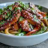 Fresh lime wedges and cilantro brighten this sesame chicken noodle bowl.