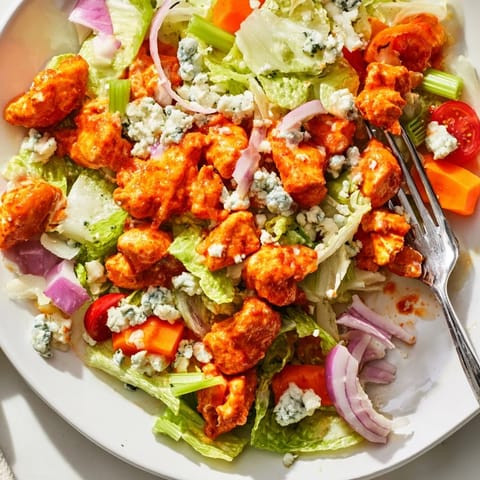 Freshly chopped romaine and spicy buffalo chicken tossed with creamy blue cheese and crisp celery in a vibrant salad.