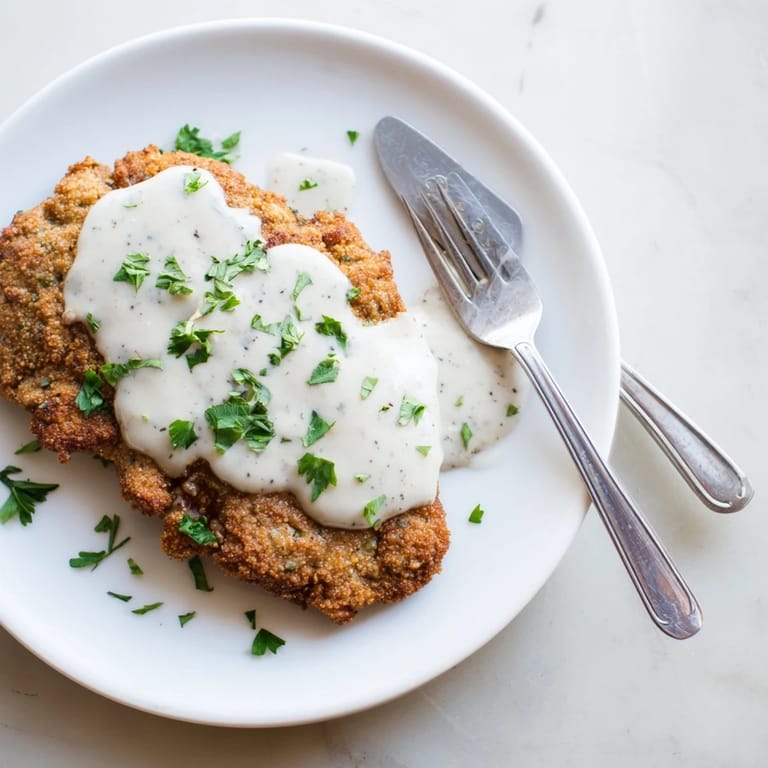 Southern-style chicken fried steak plated with fluffy mashed potatoes and creamy gravy, ready to serve for dinner.
