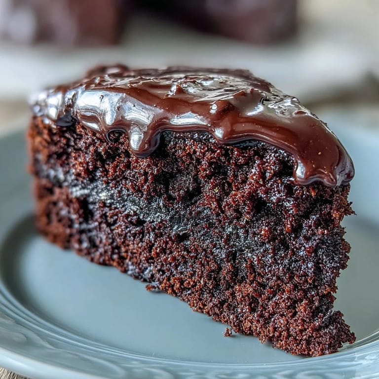 A palette knife glides across frosted Easy Chocolate Fudge Cake, smoothing silky-smooth chocolate icing over the moist, squidgy layers for a decadent finish.