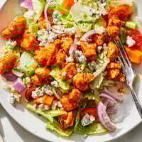 Freshly chopped romaine and spicy buffalo chicken tossed with creamy blue cheese and crisp celery in a vibrant salad.