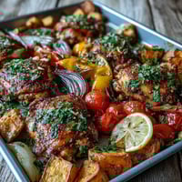 Golden-brown, juicy piri-piri chicken thighs roasted alongside tender sweet potato chunks and vibrant bell peppers on a sheet pan.