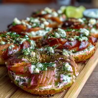 Vibrant Spring Brunch Smoked Salmon Bagel Board with Cream Cheese, fresh vegetables, and lemon wedges for a refreshing gathering centerpiece.