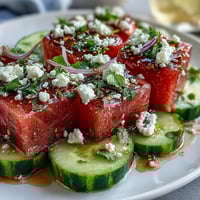 Vibrant watermelon cucumber salad with Tajin, lime, and cilantro, perfect for summer.